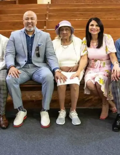 Senior care team seated with family and a senior resident | New Day Lifestyle for Seniors