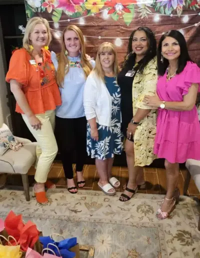 Senior placement advisor with colleagues at a tropical-themed event | New Day Lifestyle for Seniors